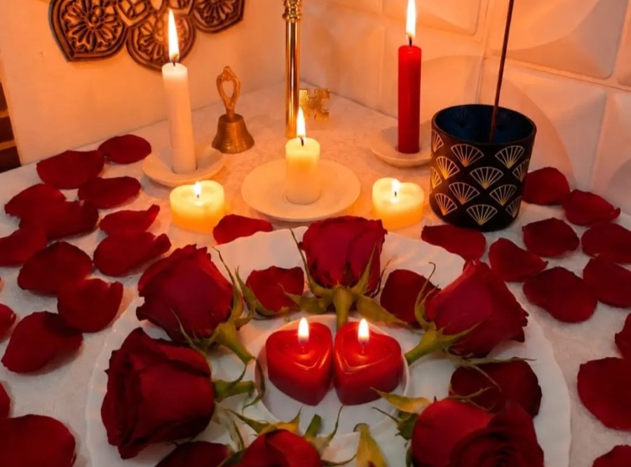 Velas acesas, chave dourada e um coração de rosas vermelhas sobre a toalha branca do altar